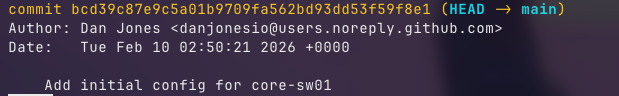 Git log output showing the first commit with hash, author, date, and commit message for the initial core-sw01 network switch configuration